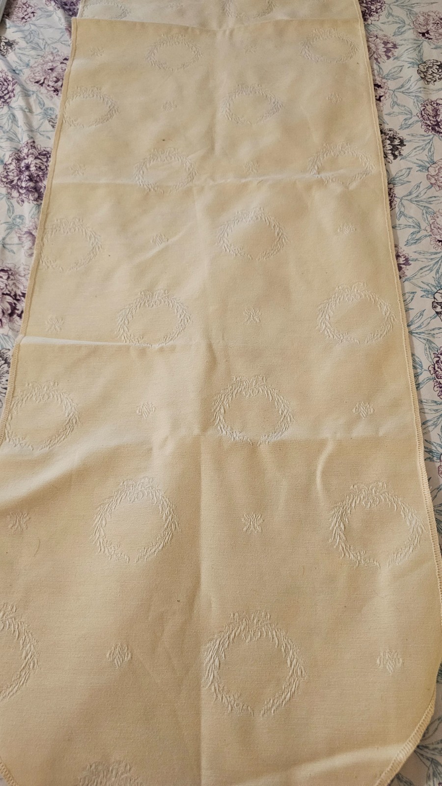 Cream colored table runner with tassled ends and wreath pattern 66 x 13 1/2 in gallery