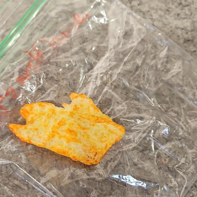 Single Cheese-Flavored Puffed Snack Piece (Cheetos-Style) in Plastic Bag gallery