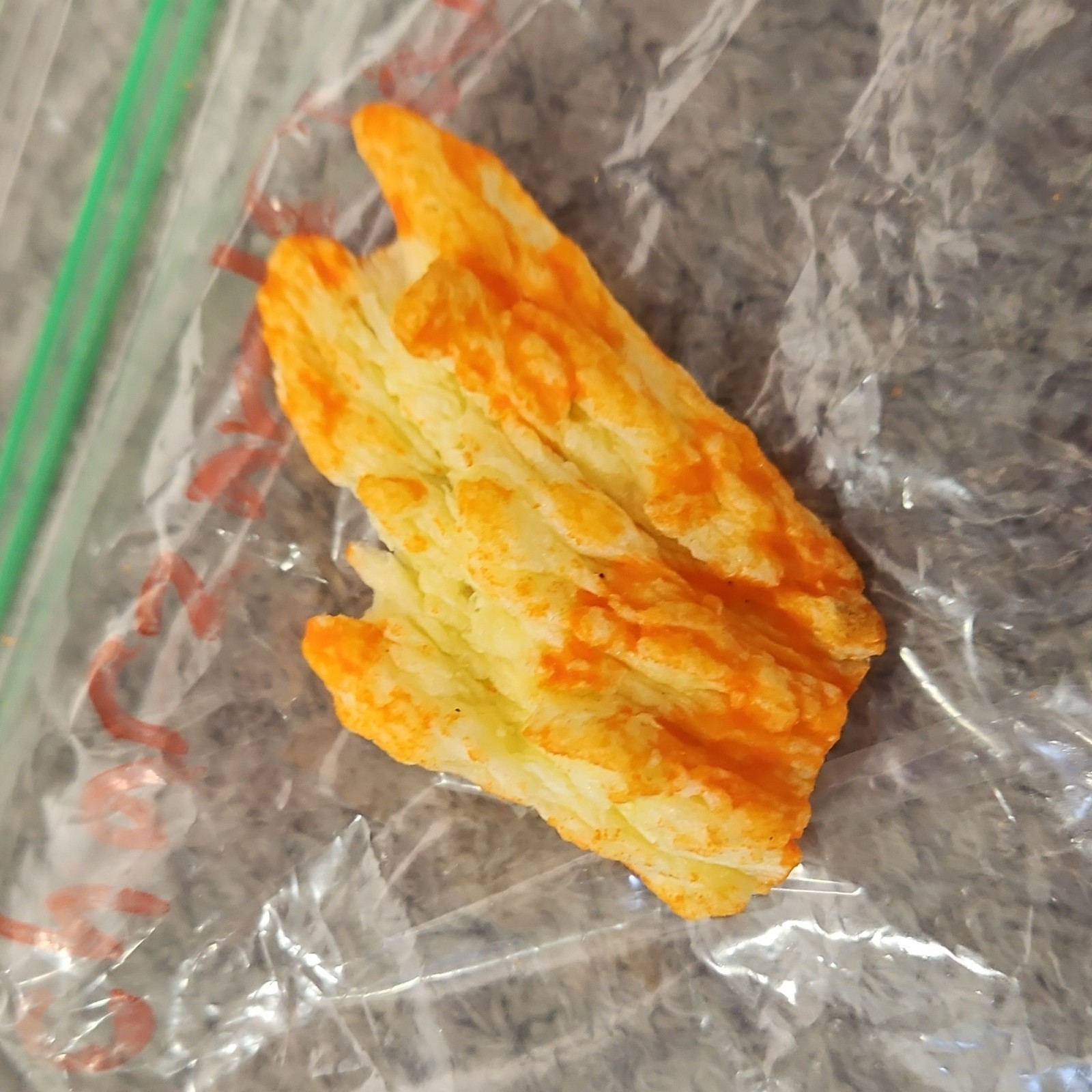 Single Cheese-Flavored Puffed Snack Piece (Cheetos-Style) in Plastic Bag gallery