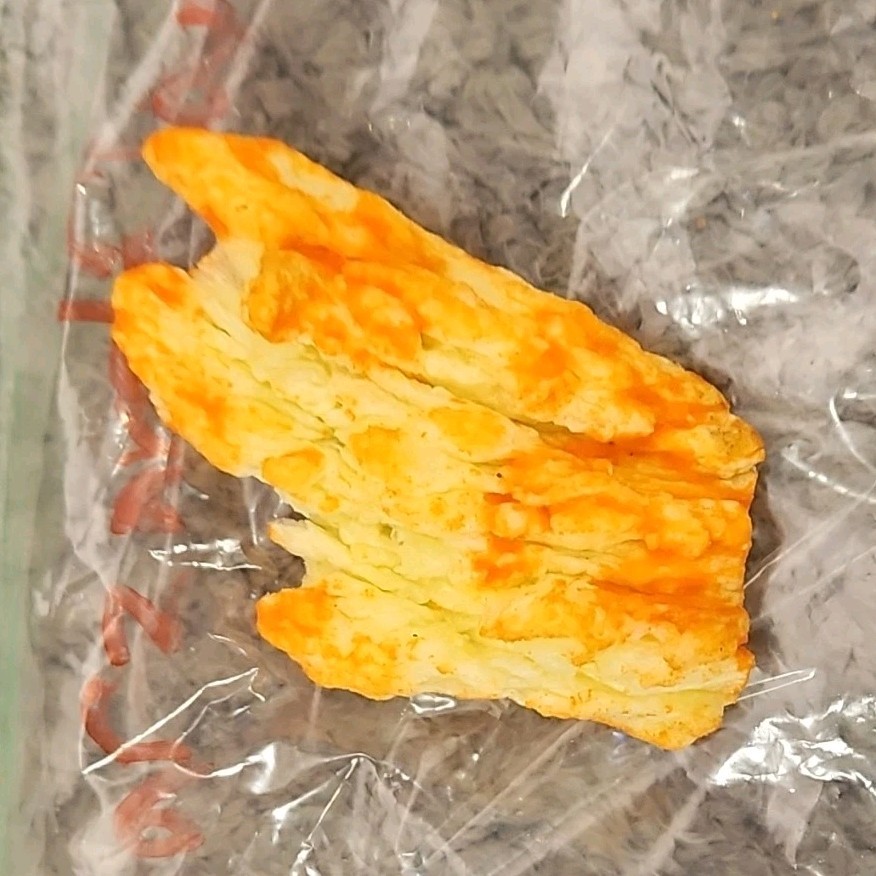 Single Cheese-Flavored Puffed Snack Piece (Cheetos-Style) in Plastic Bag gallery